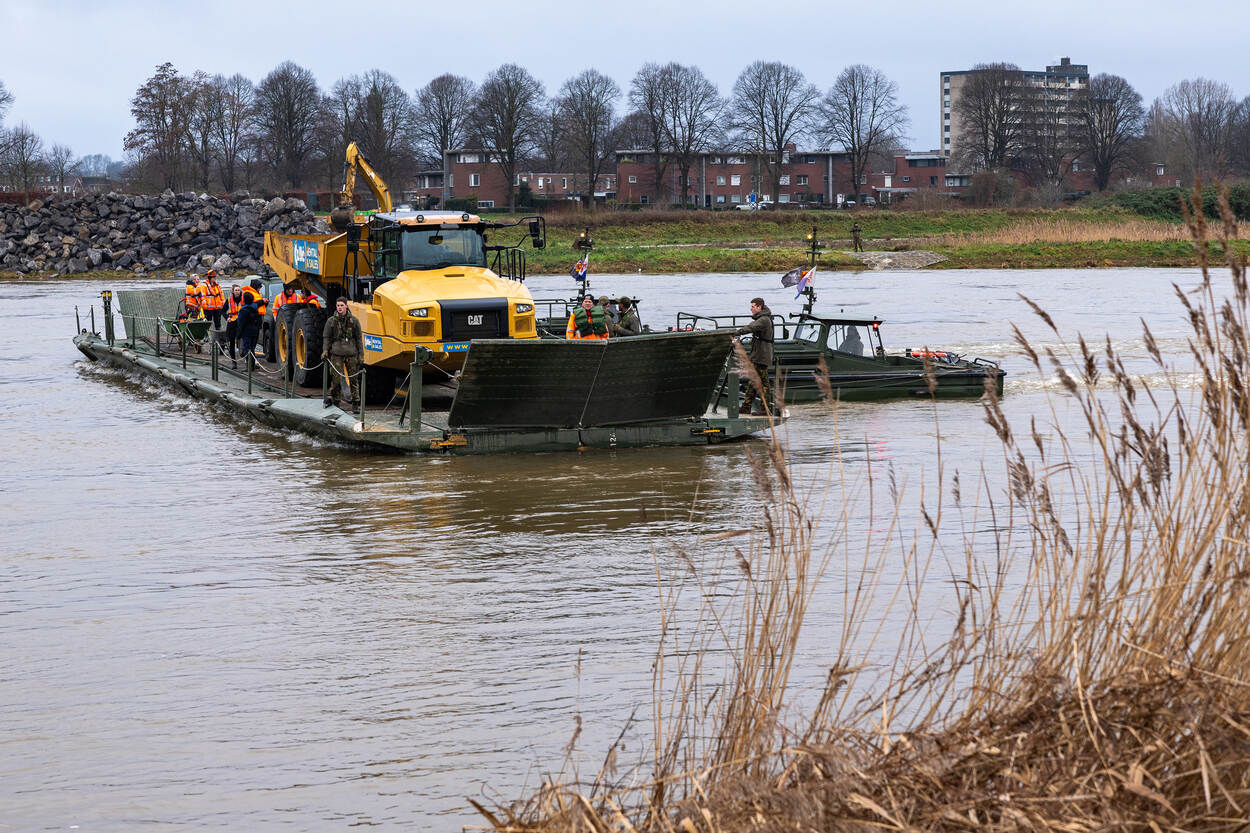 Militairen van 105 Genietroepen waterbouw brengen zwaar materieel naar de overkant.