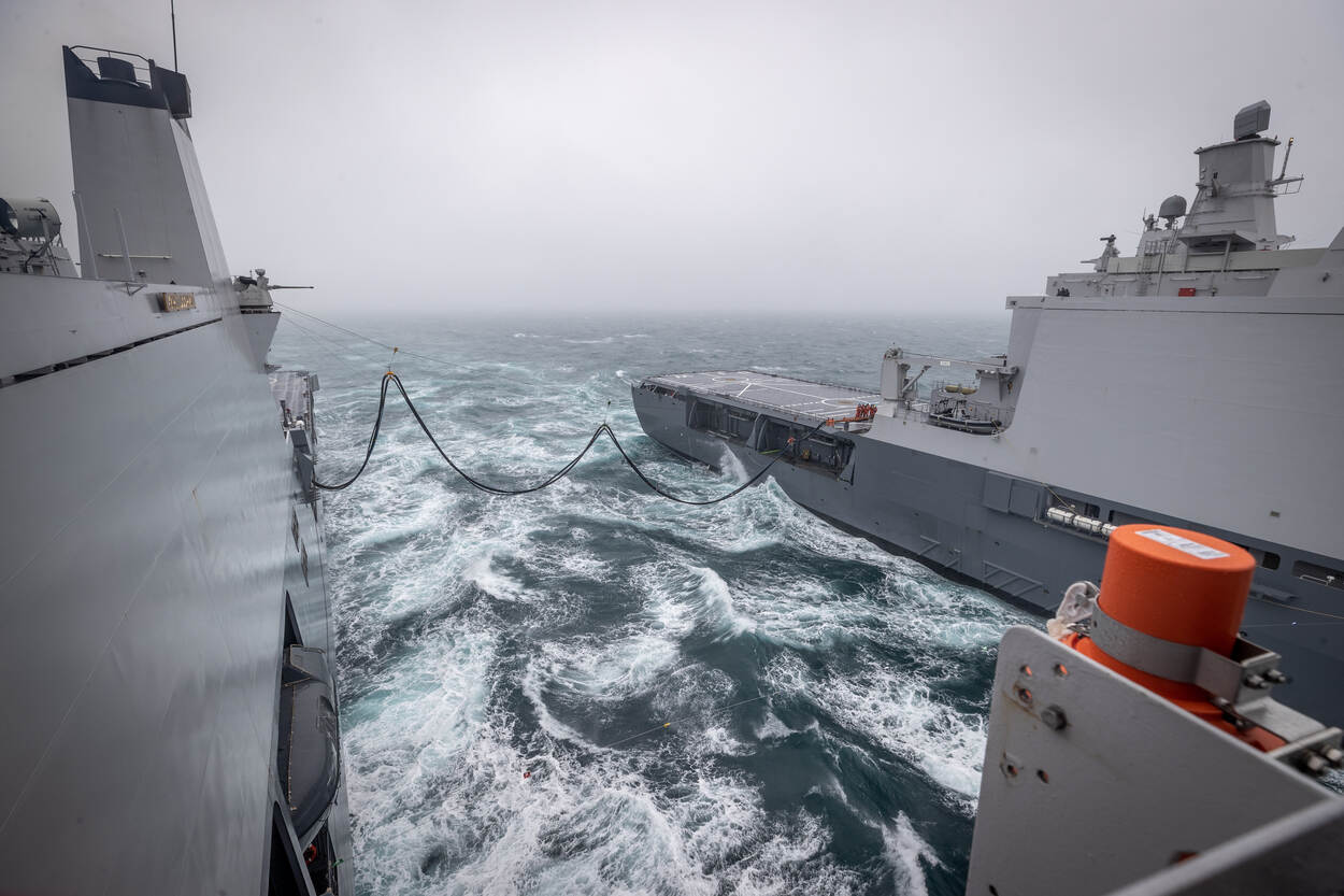 Zr.Ms. Karel Doorman en Zr.Ms. Johan de Witt op zee bij Zuid-Engeland. Een tankslang verbindt de schepen.