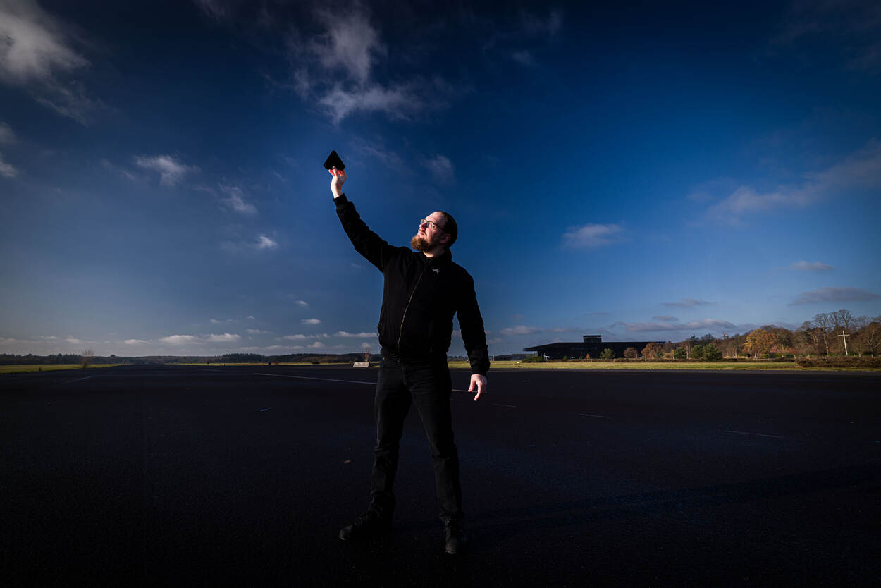 Documentairemaker Bram Roza voor een groot bioscoopscherm waar zijn documentaire wordt afgespeeld.