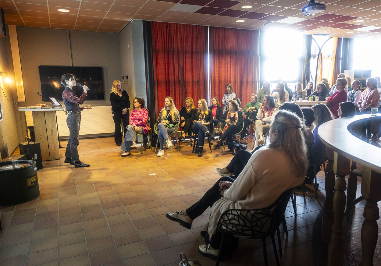 Vrouwen luisteren naar een lezing op een netwerkevent voor Internationale Vrouwendag.