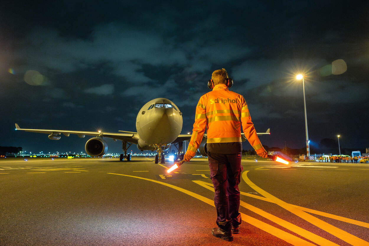 Grondmedewerker luchthaven geeft piloot instructies tijdens het taxiën.