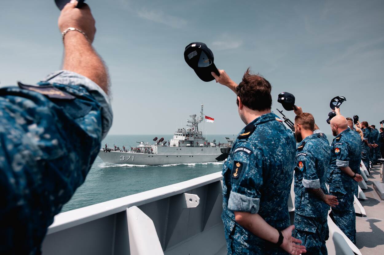 De scheepsbemanning wuift een korvet van de Indonesische marine uit.