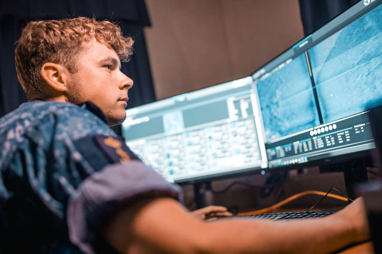 Marineman volgt vanachter beeldschermen de verrichtingen van drones.