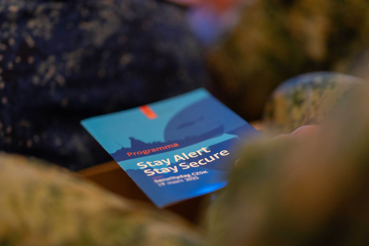 Het programmaboekje met daarop de leus Stay Alert Stay Secure.