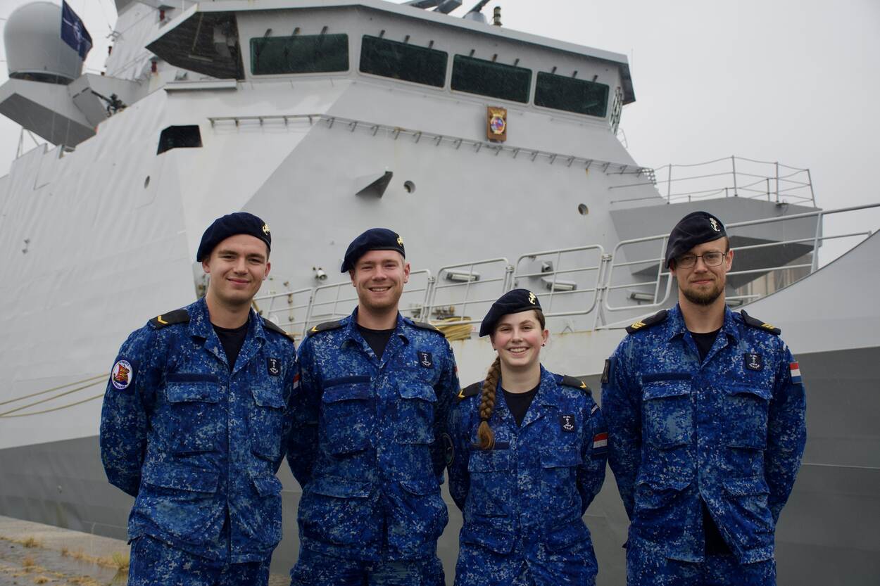 De leerlingen en hun docent staan voor Zr.Ms. De Ruyter.