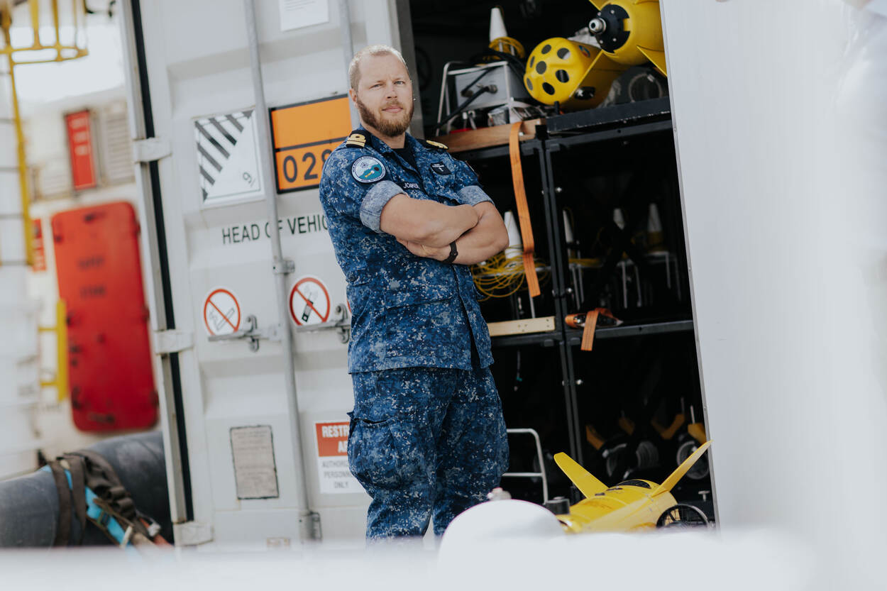 LTZ 2OC Richard Jonkers poseert met zijn armen over elkaar voor een container met drones.