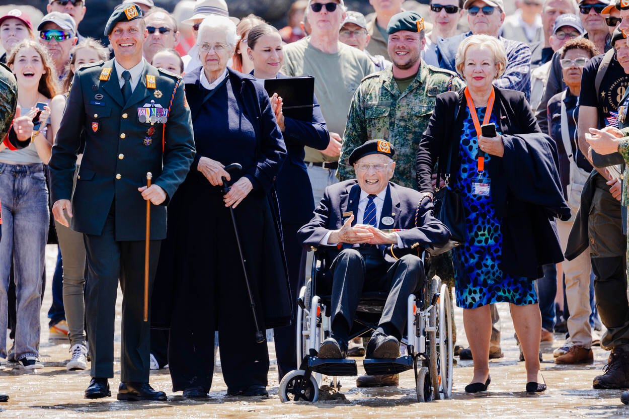 Een lachende luitenant-kolonel Verhoef en Max Wolff aanschouwen hoe de laatste drie fuseliers een nat pak halen. Daarnaast nog enkele andere personen.