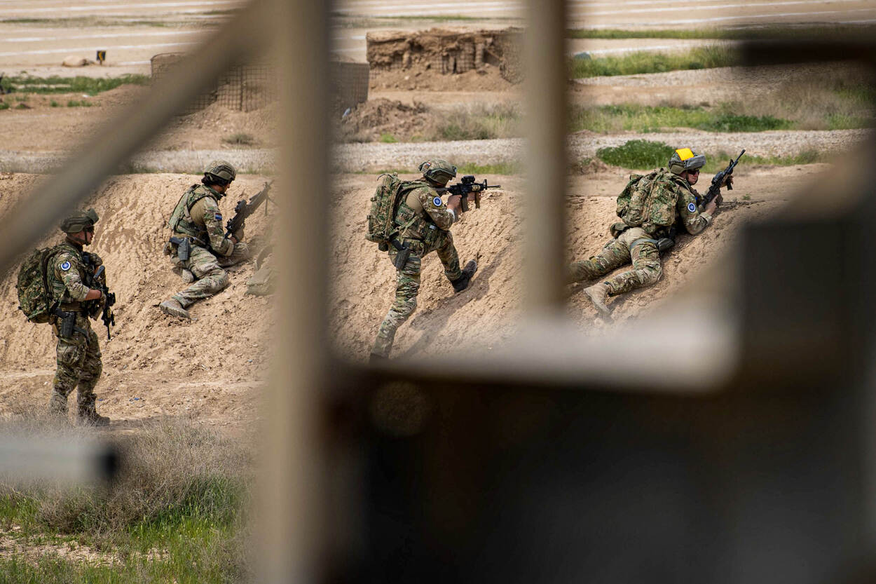 Nederlandse luchtmobielers liggen tegen een zandheuvel op oefenterrein Besmaya in Irak.