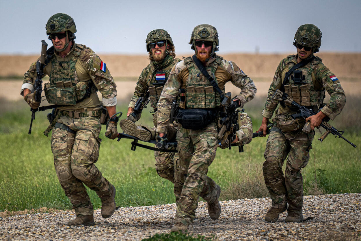 Nederlandse militairen van 11 Luchtmobiele Brigade evacueren een gewonde militair op een brancard.