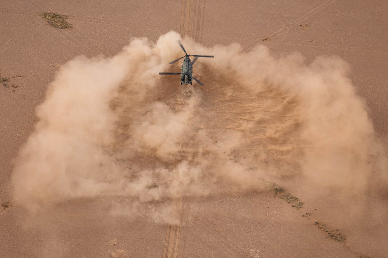 Landende Chinook in de woestijn, van de bovenkant bezien.