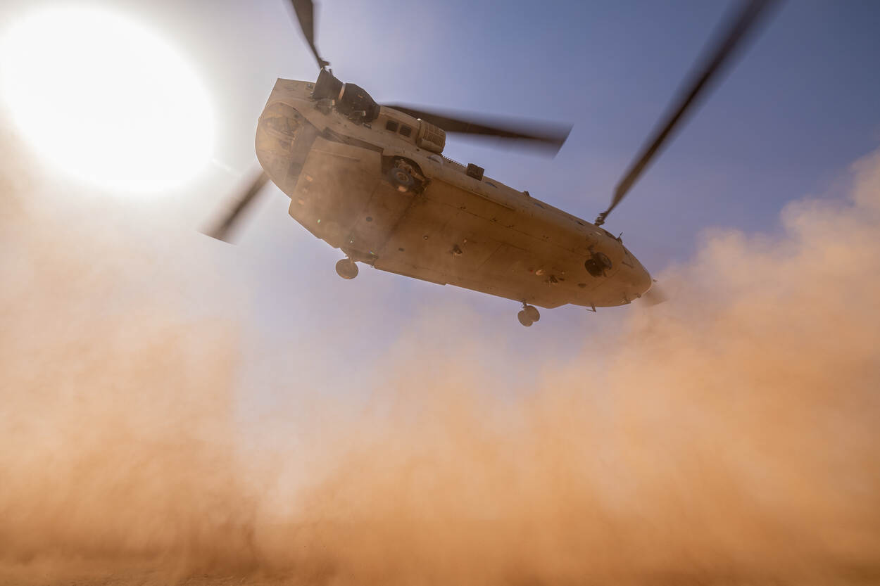 Landende Chinook in de woestijn, van de onderkant bezien.