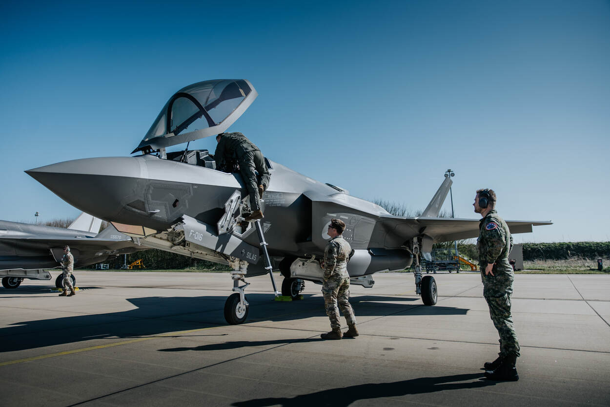 Grondpersoneel assisteert een vlieger bij het instappen in een F-35.