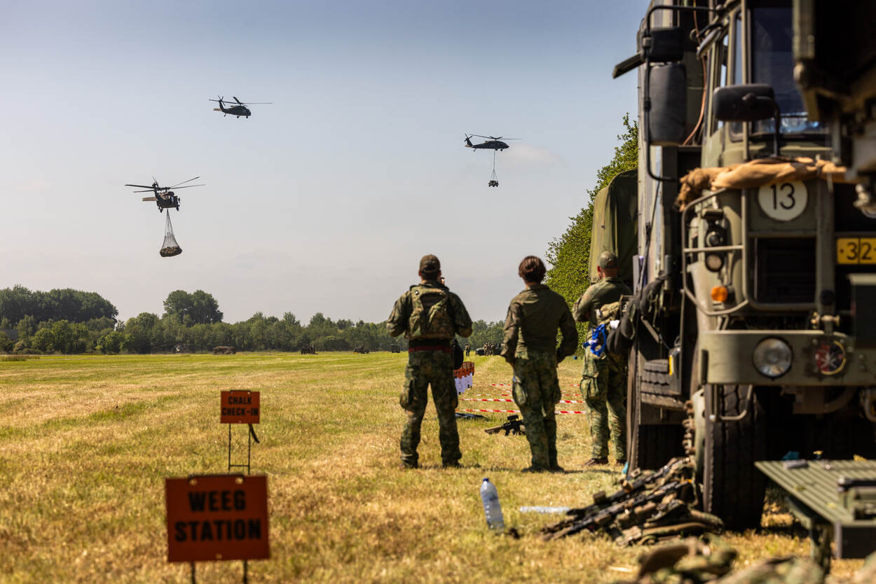 Helikopters met slingload vertrekkend vanaf een grasveld.