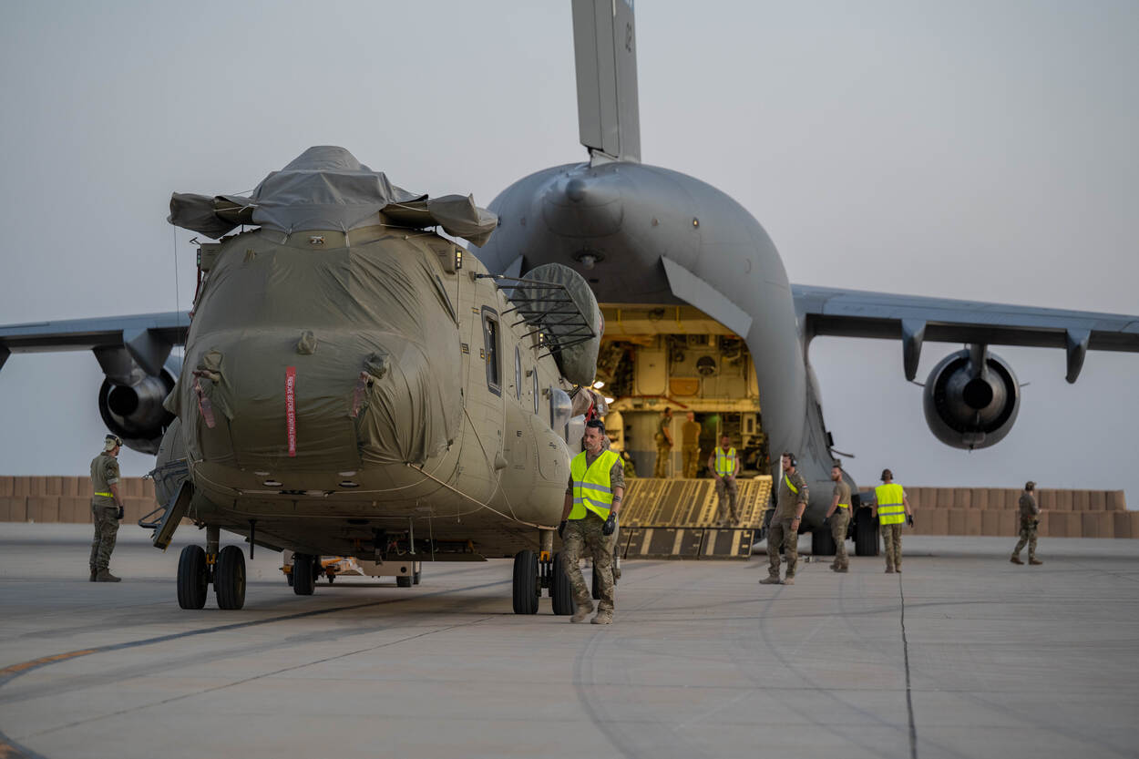 Transporthelikopter wordt in ruim vliegtuig geschoven.