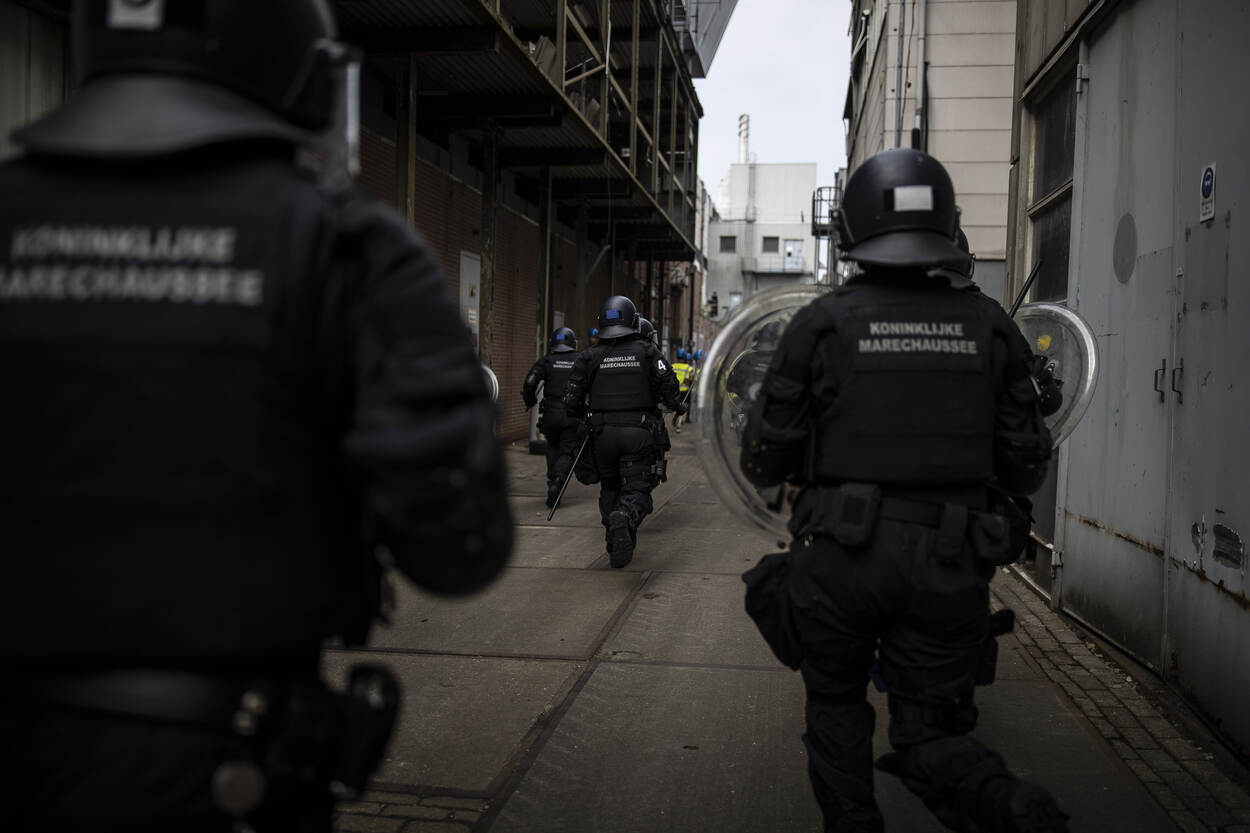 De ME loopt door een nauw straatje.