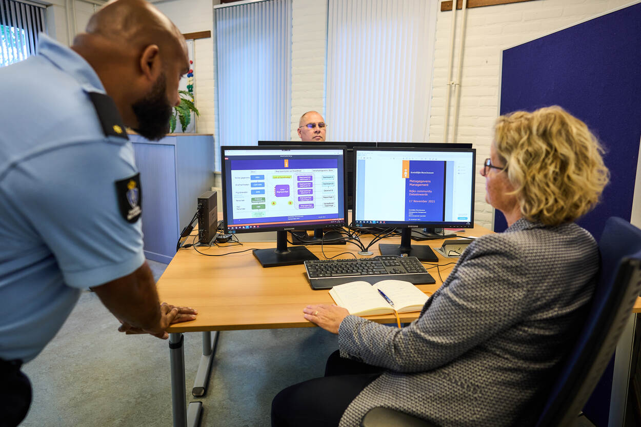 2 collega's van de afdeling Metagegevens Management voeren achter een computer overleg.