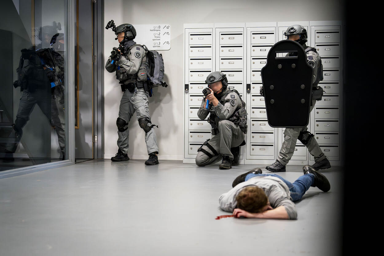 Het arrestatie- en ondersteuningsteam in actie tijdens het schoolshooting-scenario en een gewonde persoon op de voorgrond.