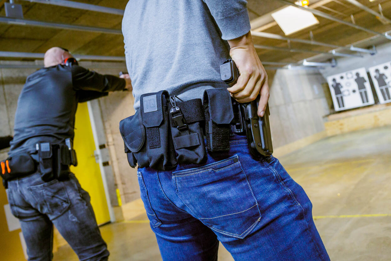 2 collega's trekken hun wapen. Ze volgen de opleiding tot persoonsbeveiliger.