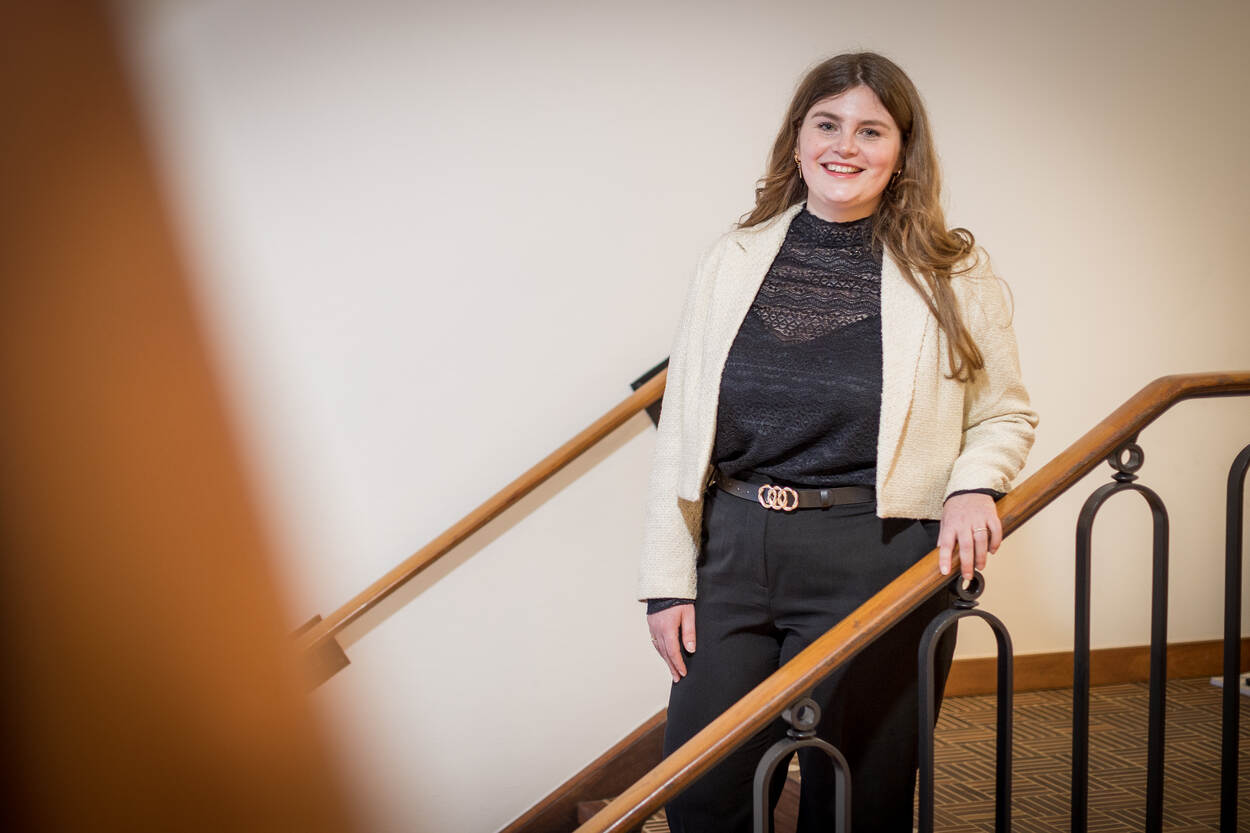 Portretfoto op een trap van Roxanne, coördinator Bureau Bijzondere Instroom.