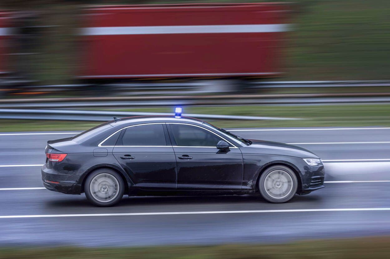 Marechaussee rijdt op volle snelheid met blauw zwaailicht.