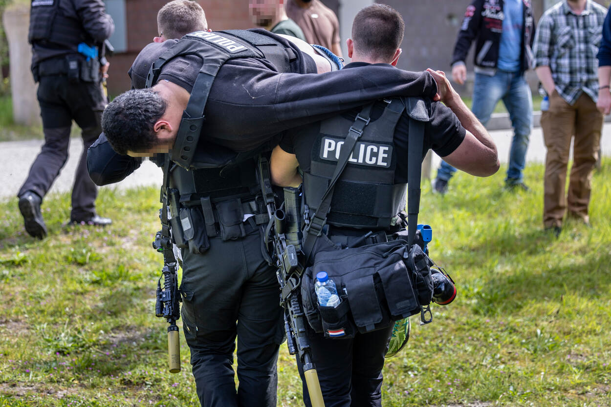 Een gewonde collega wordt over de schouder gelegd en weggedragen.