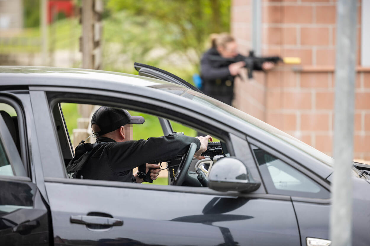 Persoonsbeveiligers houden een groep mensen onder schot tijdens de oefening.
