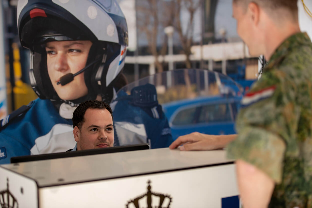 Wachtmeester-1 Jeroen helpt een militair aan de balie.