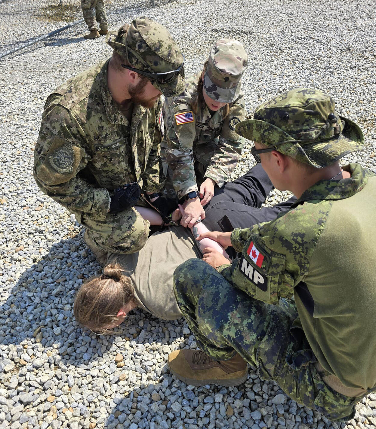 3 militairen leggen een arrestant op de grond