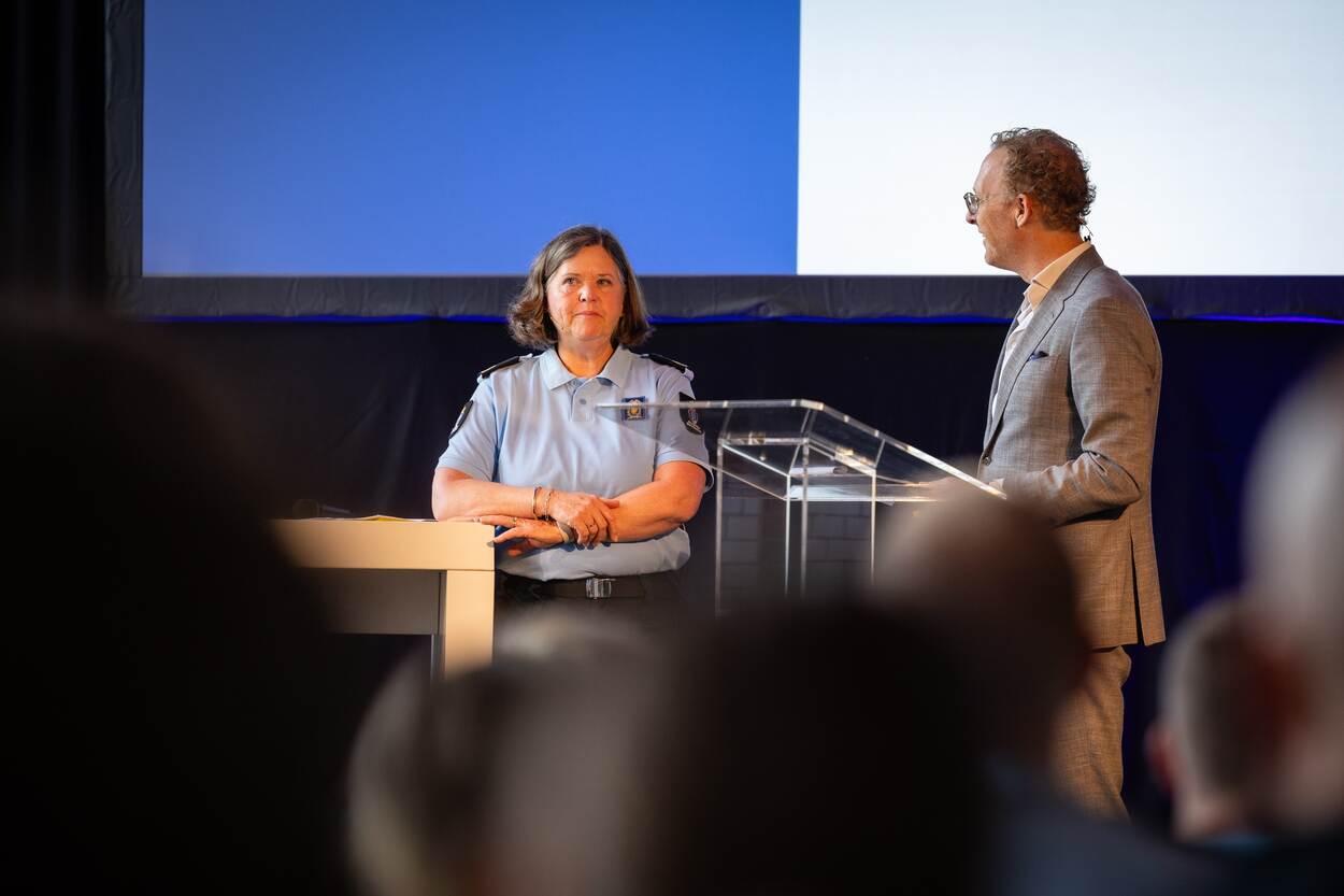 Generaal Roelofs en dagvoorzitter De Jong staande op een podium.