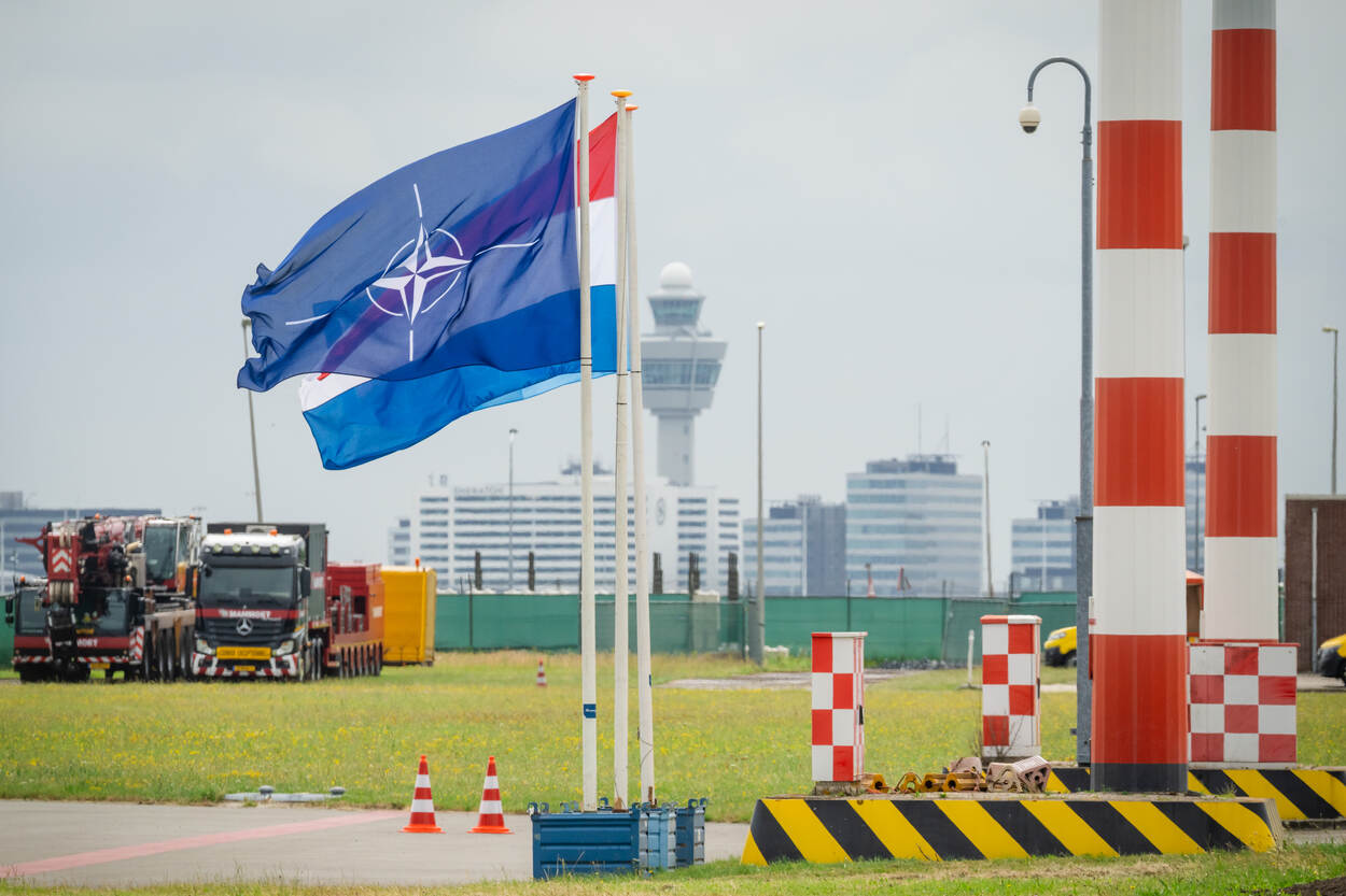 Vlag NAVO met Schiphol op de achtergrond.