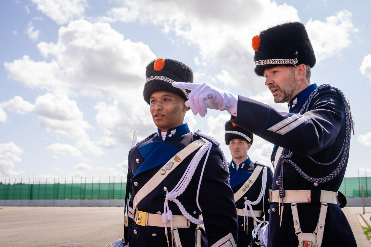 Een leerling-marechaussee luistert naar de aanwijzingen van zijn commandant.