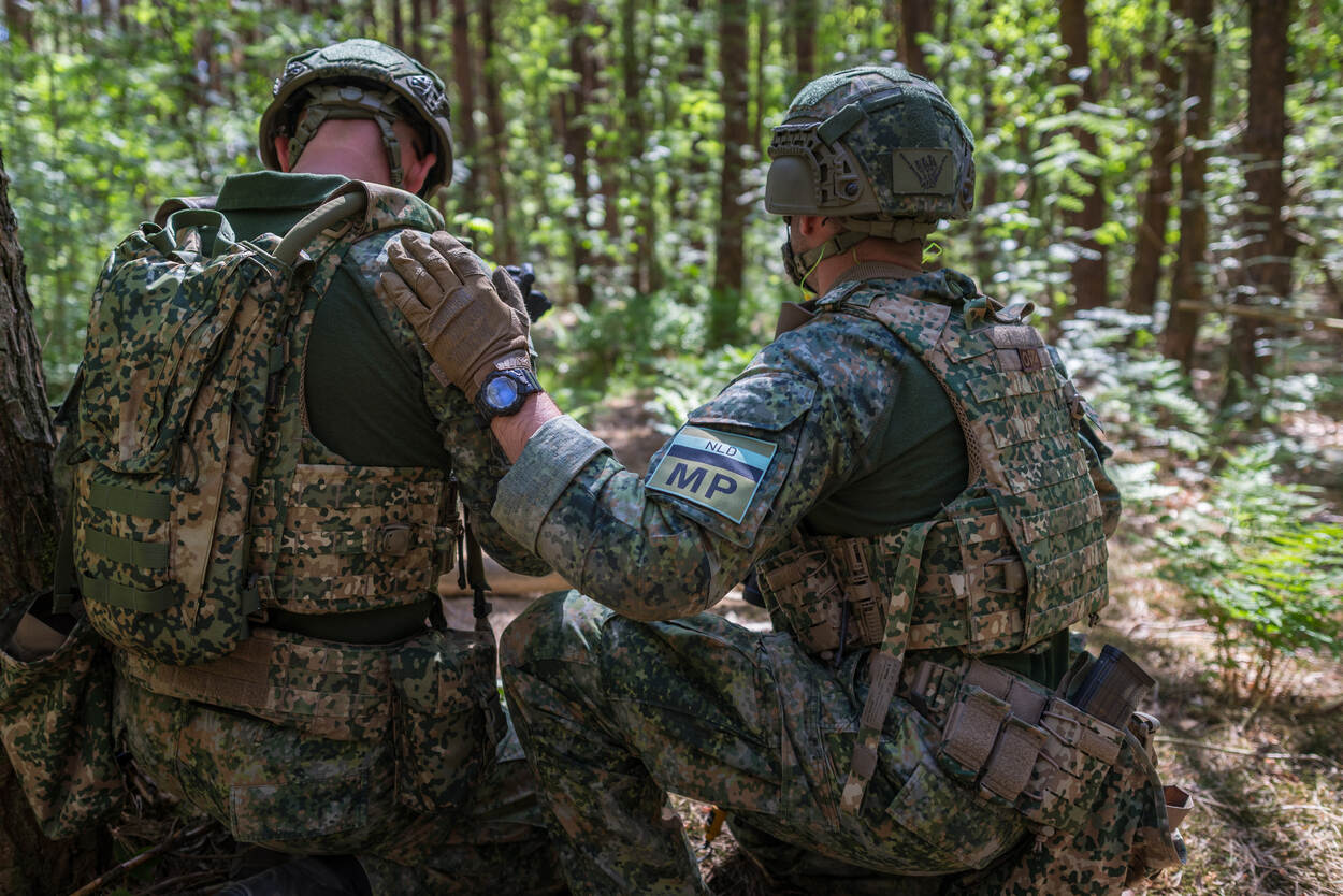 Marechausse van 101 Marbat met hand op schouder van collega.