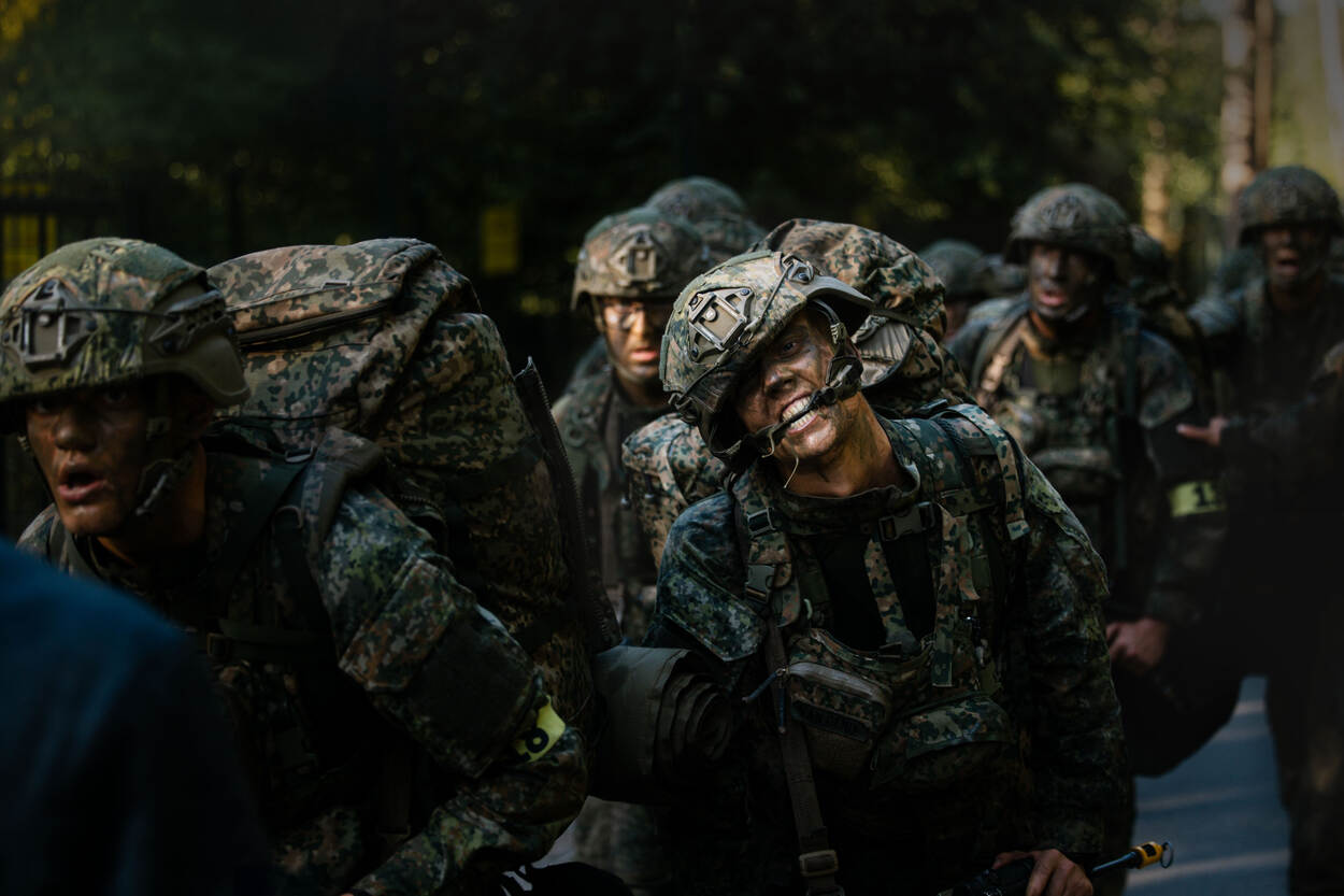 Een deelnemer bijt verbeten op z’n helmriem tijdens de afsluitende mars.
