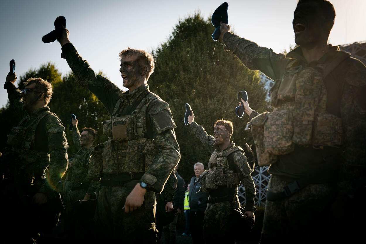 Marechaussees in opleiding houden hun baret in de lucht.
