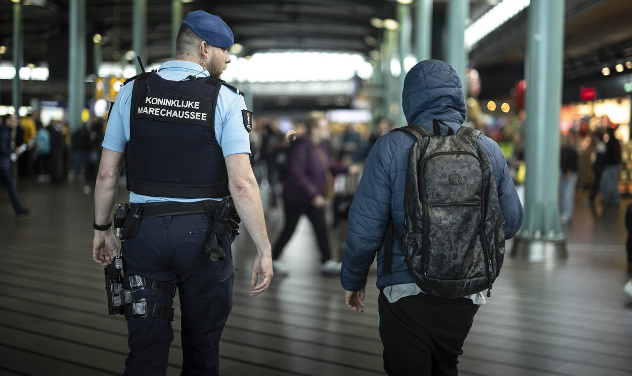 Bart begeleidt een dakloze naar het kantoor van de Marechaussee op Schiphol Plaza.