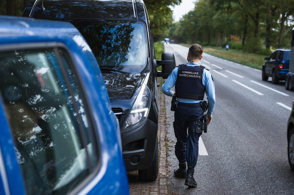 Een op de rug gezien terwijl hij richting een voertuig loopt.