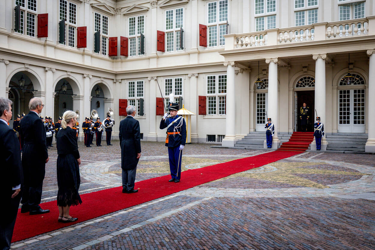 Een marechaussee heet een ambassadeur welkom op Paleis Noordeinde.