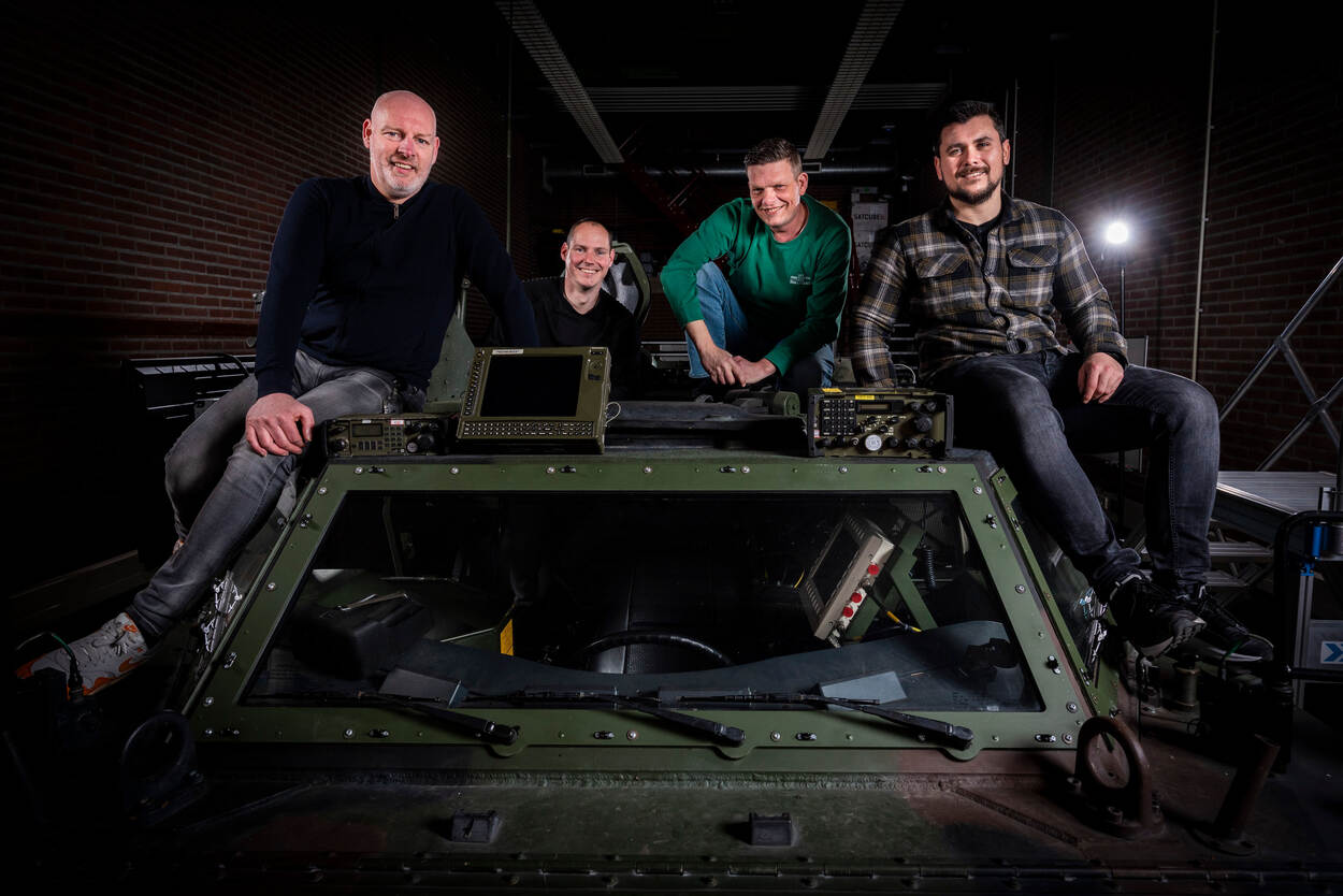 Groepsfoto van het integratie testteam (ITT) van JIVC/Landgebonden IT op een Fennek verkenningsvoertuig