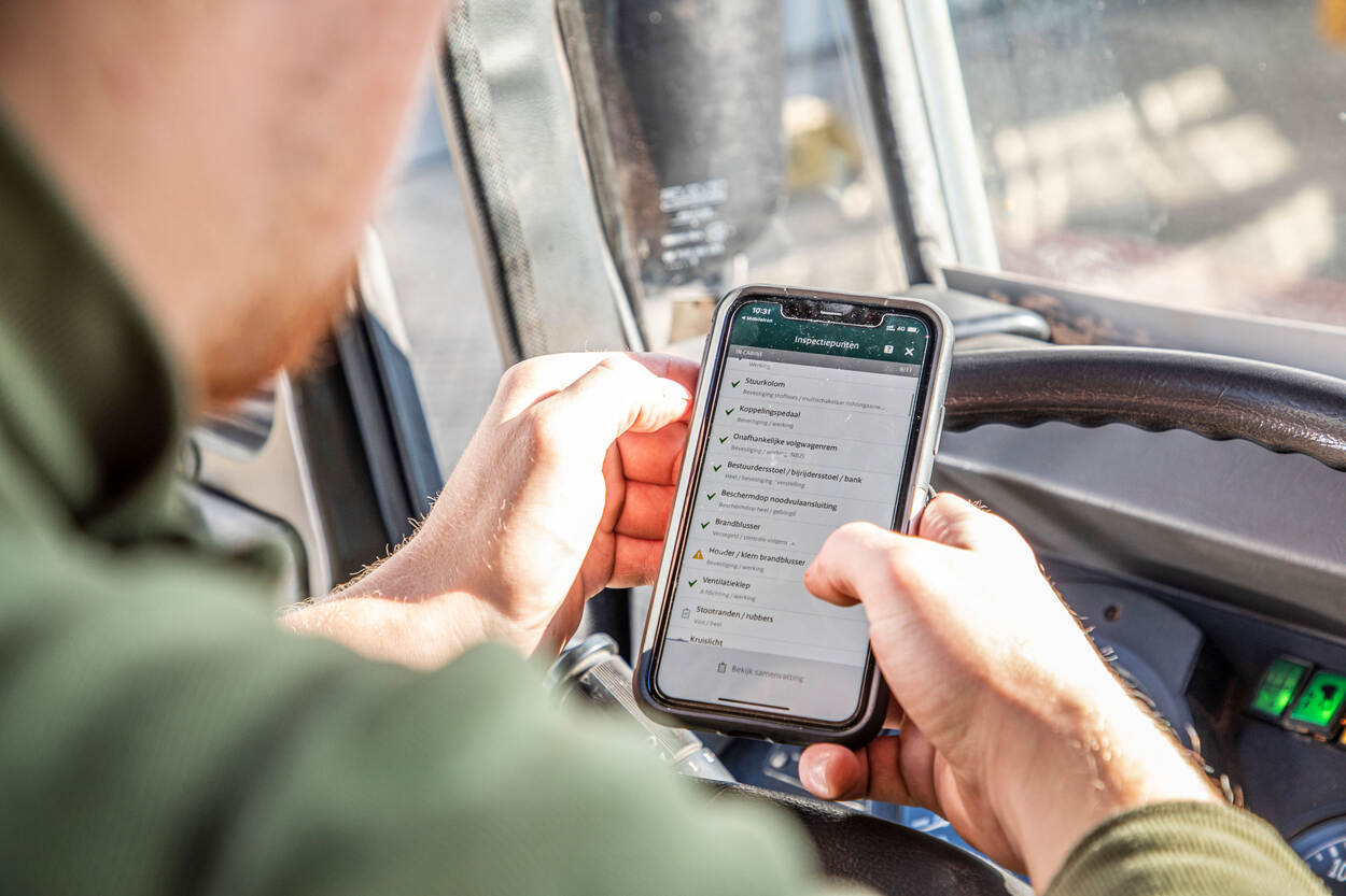 Closeup van een smartphone met de app DO-MAINT in de handen van een militair.