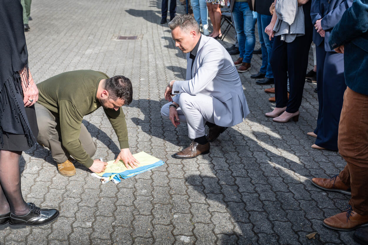 President Zelensky signeert de Oekraïense vlag van COMMIT-medewerker Teun.