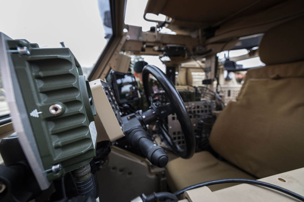 Vaag interieur van een Vector-terreinwagen met scherp op voorgrond een speaker voor het intercomsysteem.