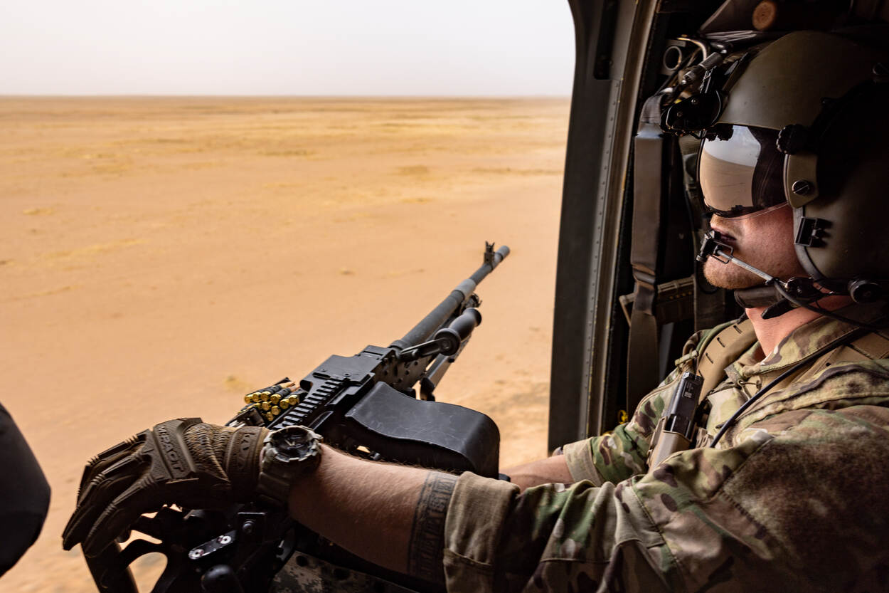 Doorgunner zit in Chinook en kijkt naar buiten.