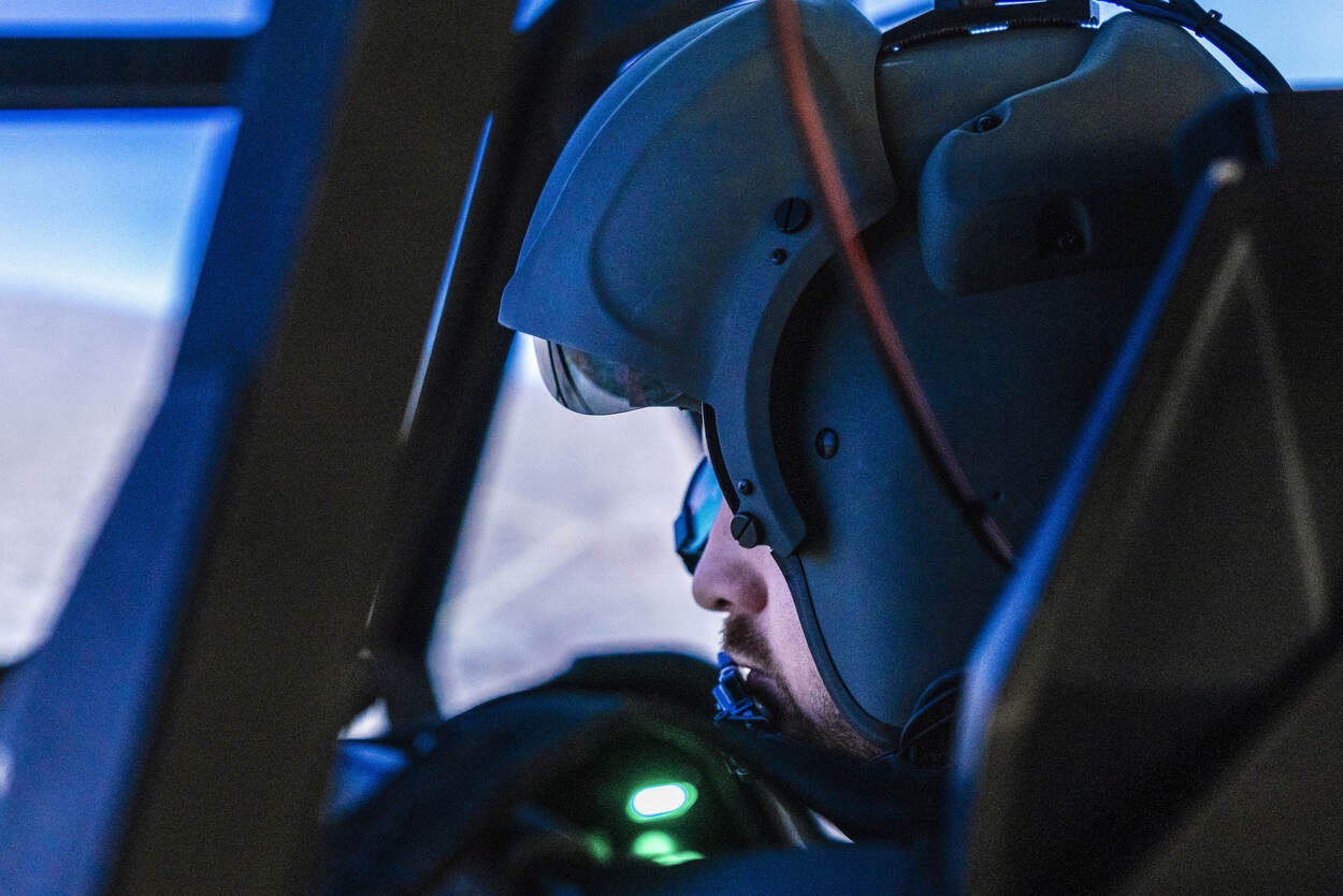 Apache-vlieger met helm zit in simulator.