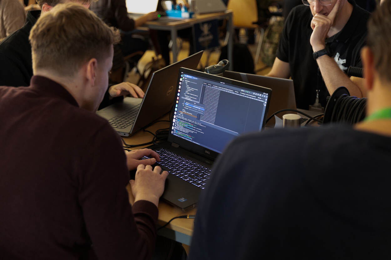 Een aantal personen achter hun laptop.