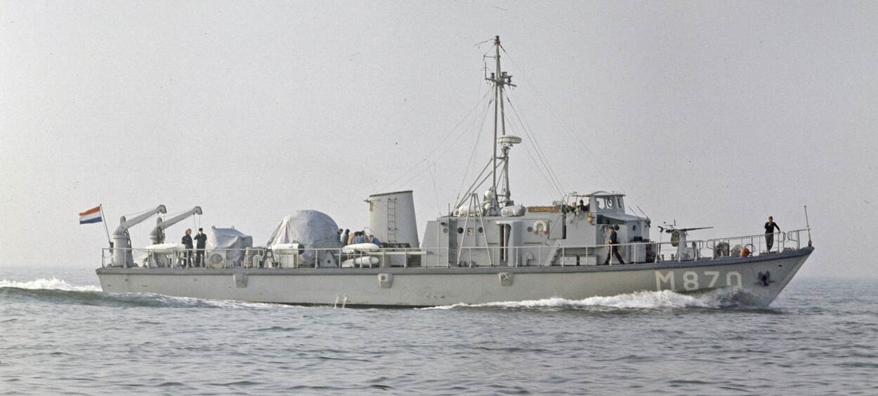 Een grijs schip op een kalme zee in zwart-wit.