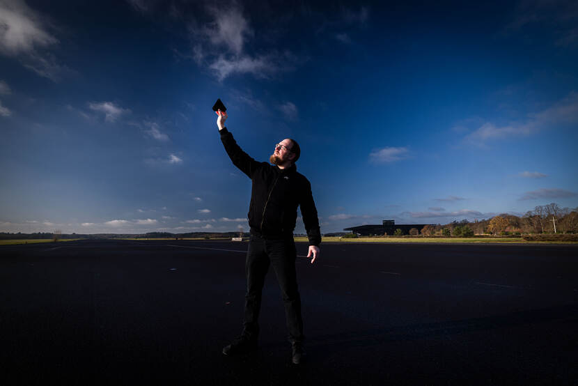 Documentairemaker Bram Roza voor een groot bioscoopscherm waar zijn documentaire wordt afgespeeld.
