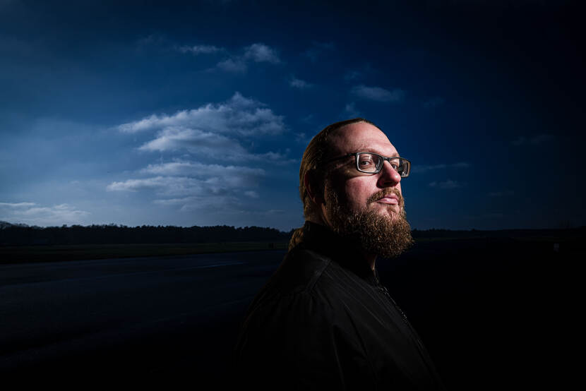 Close-up foto van documentairemaker Bram Roza, met rossige baart en bril.