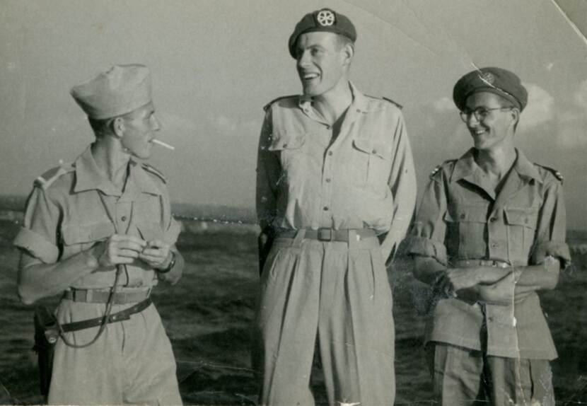 Archieffoto in sepia van Bert Carper en collega’s in een militaire Jeep met open dak.