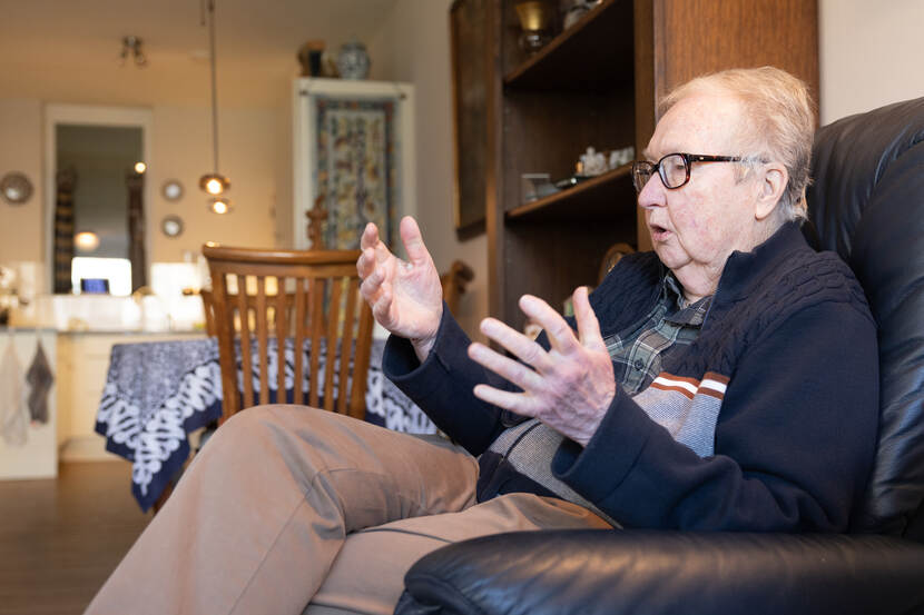 Judith zit op een stoel en vertelt, met haar handen gebarend.