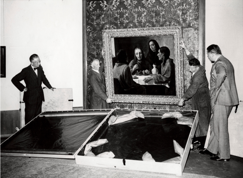 Schilderij wordt van de muur gehaald met op de grond een lege box waarin deze bewaard wordt.